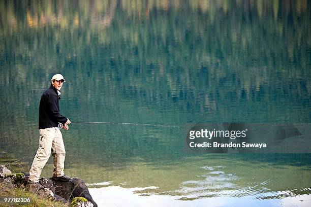 a man fly fishes lake crescent in washington's olympic national park. - lago crescent foto e immagini stock