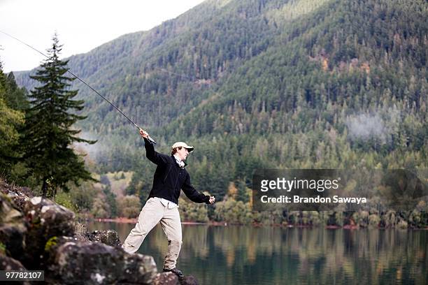 a man fly fishes lake crescent in washington's olympic national park. - lago crescent fotografías e imágenes de stock