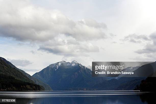 a still lake crescent beneath snow capped hills in the distance, in washington's olympic national pa - lago crescent fotografías e imágenes de stock
