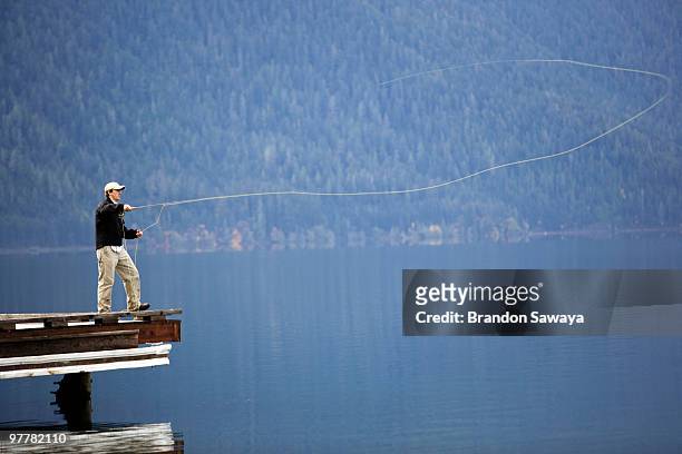a man fly fishes lake crescent in washington's olympic national park. - lago crescent fotografías e imágenes de stock