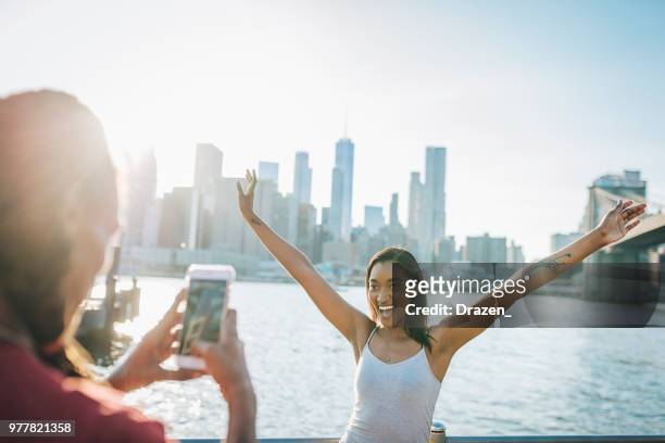 bella donna che allunga le braccia vicino al ponte di brooklyn - panorama nyc day 2 foto e immagini stock