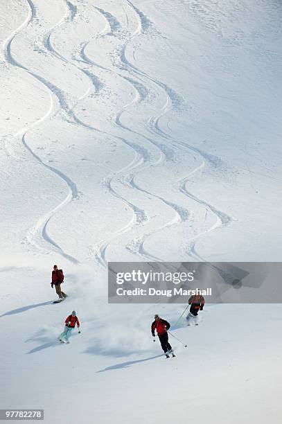 a group of backcountry skiers follow their guide down a slope in the selkirk mountains, canada. - vers le bas photos et images de collection