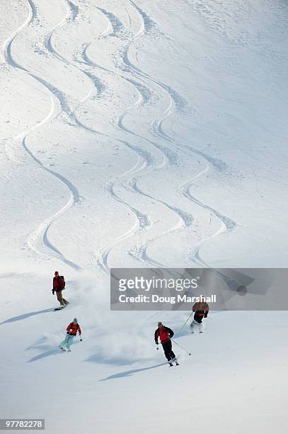 a group of backcountry skiers follow their guide down a slope in the selkirk mountains, canada. - slalom stockfoto's en -beelden