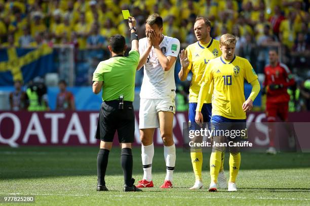 Referee Joel Aguilar of Salvador gives a yellow card to Kim Shin-wook of South Korea during the 2018 FIFA World Cup Russia group F match between...