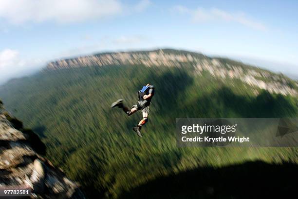 a base jumper leaps off a cliff in the blue mountains, new south wales, australia. - base jumping imagens e fotografias de stock