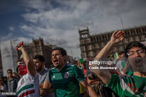 Soccer fans react while watching a monitor broadcasting the Group F opening match of the FIFA World Cup between Mexico and Germany at a viewing party...