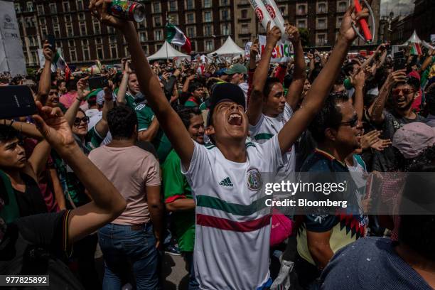 Soccer fans react while watching a monitor broadcasting the Group F opening match of the FIFA World Cup between Mexico and Germany at a viewing party...