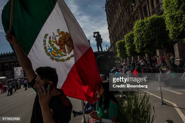 Soccer fan waves a Mexican flag during the Group F opening match of the FIFA World Cup between Mexico and Germany at a viewing party in the Zocalo in...