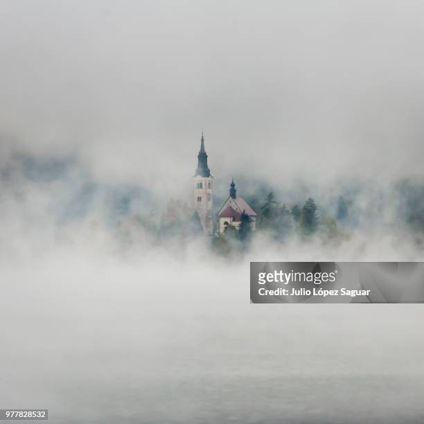 church in mist, niebla, slovenia - niebla stock-fotos und bilder