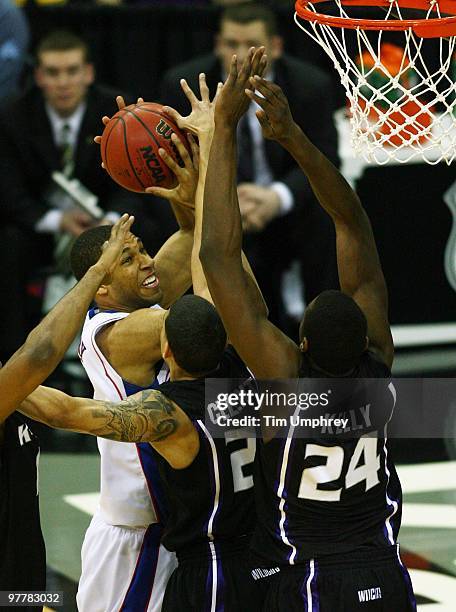 Xavier Henry of the Kansas Jayhawks goes up for a shot while defended by multiple Kansas State Wildcats in the 2010 Phillips 66 Big 12 Men's...