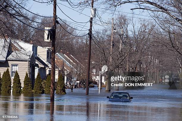 Car is abandoned on a street filled with floodewaters from the Passaic River on March 16, 2010 in Little Falls, New Jersey. Many residents who have...