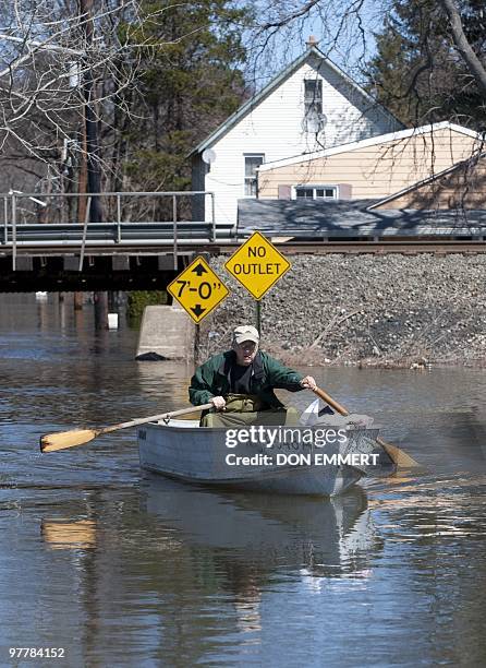 Local resident Ray Breimer paddles a rowboat on a street filled with floodewaters from the Passaic River on March 16, 2010 in Little Falls, New...