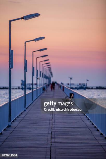 people walking on bridge at sunset, constanta, romania - mamaia romania stock pictures, royalty-free photos & images