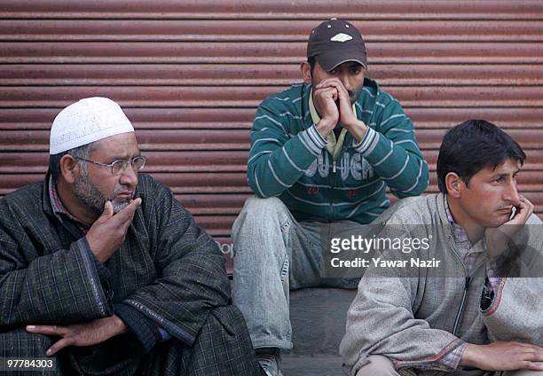 Neighbours look towards the dead body of Khursheed Ahmad a salesman who was killed in a shoot out between Indian Police and suspected militants being...