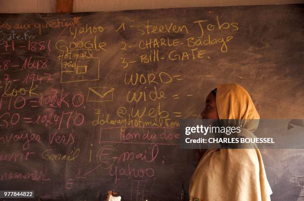 Husseina, a 17 years old displaced, who wants to become a computer scientist, poses next to a blackboard at a IT learning centre in the IDP camp at...