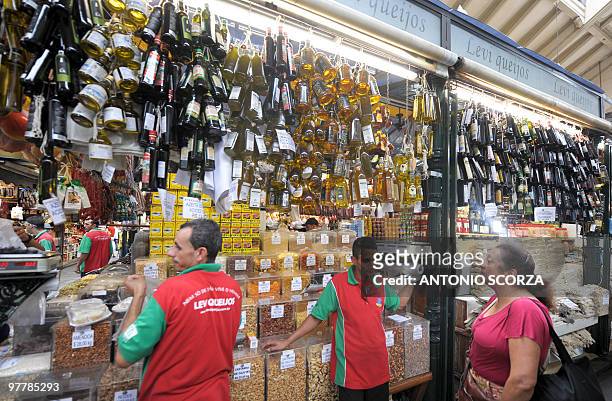 Customer chooses olive oil in the municipal market in Sao Paulo, Brazil, on March 15, 2010. AFP PHOTO/Antonio Scorza