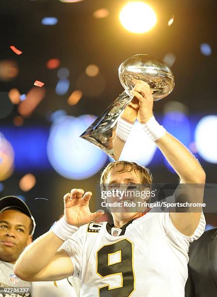 Drew Brees of the New Orleans Saints holds up the Vince Lombardi Trophy on the podium after defeating the Indianapolis Colts in Super Bowl XLIV on...