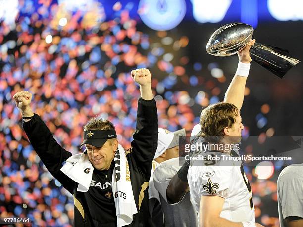 Drew Brees of the New Orleans Saints holds up the Vince Lombardi Trophy on the podium as head coach Sean Payton looks on after defeating the...