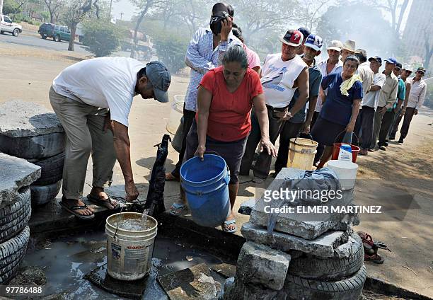 Local residents line up to collect potable water from a public tap in Managua on March 16, 2010. The effects of global warming are already affecting...