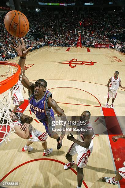Amare Stoudemire of the Phoenix Suns lays up a shot against Luis Scola and Joey Dorsey of the Houston Rockets during the game on January 31, 2010 at...