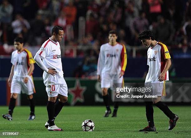 Luis Fabiano of Sevilla stands dejected with his team mates after conceding a goal during the UEFA Champions League round of sixteen second leg match...