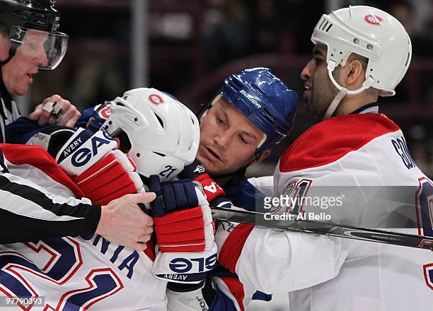 Sean Avery of the New York Rangers has Brian Gionta of the Montreal Canadiens in a headlock as Scott Gomez of the Canadiens assists Gionta during...