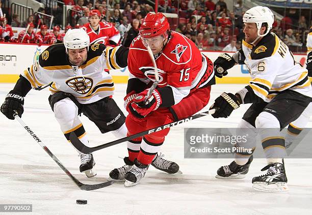 Tuomo Ruutu of the Carolina Hurricanes splits Mark Stuart and Dennis Wideman of the Boston Bruins during their NHL game on March 16, 2010 at the RBC...