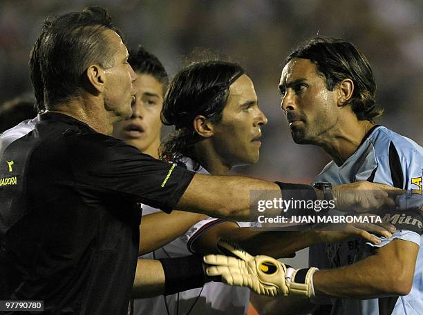 Argentina's Banfield goalkeeper Cristian Lucchetti argues with Brazilian referee Wilson Luiz Seneme next to Uruguay's Nacional midfielder Alvaro...
