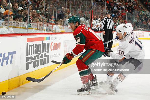 Andrew Ebbett of the Minnesota Wild and Shawn Horcoff of the Edmonton Oilers battle for control of the puck along the boards during the game at the...