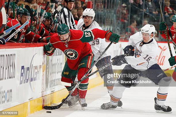 Chuck Kobasew of the Minnesota Wild fights for control of the puck with Chris Minard and Ryan Potulny of the Edmonton Oilers during the game at the...