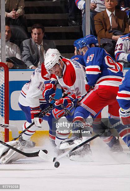 Mathieu Darche of the Montreal Canadiens struggles to gain control of the puck against Matt Gilroy of the New York Rangers in the second period on...