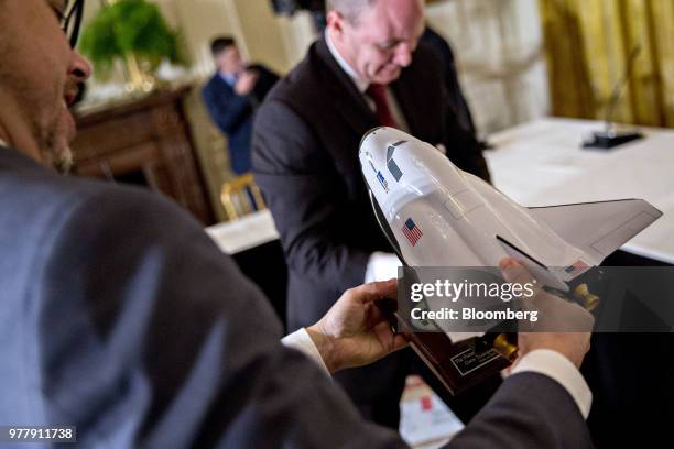 Man holds a model spacecraft before a National Space Council meeting in the East Room of the White House in Washington, D.C., on Monday, June 18,...