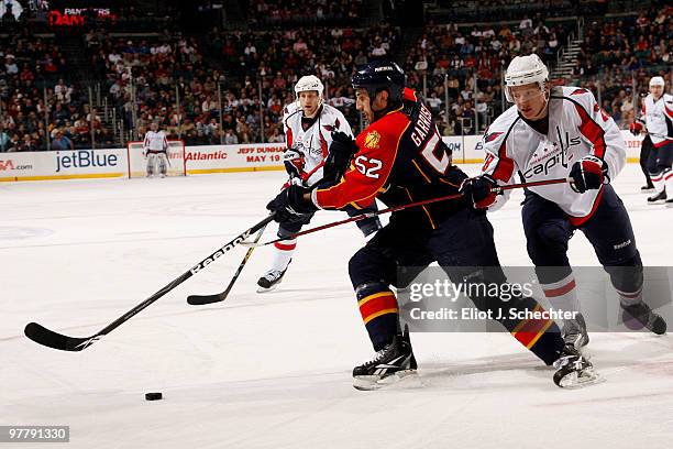 Jason Garrison of the Florida Panthers crosses sticks with Alexander Semin of the Washington Capitals at the BankAtlantic Center on March 16, 2010 in...