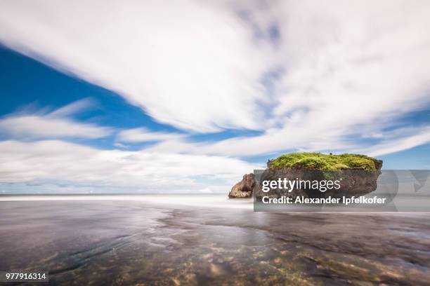 rocks with greenery on top surrounded by calm water, yogyakarta, java, indonesia - alexander ipfelkofer stock pictures, royalty-free photos & images