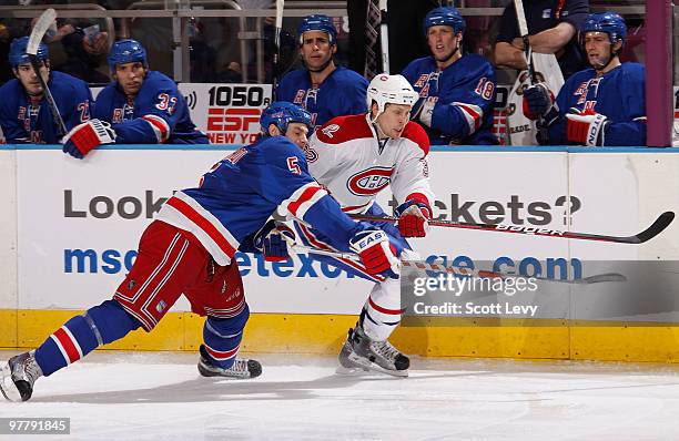 Dan Girardi of the New York Rangers skates for the puck against Travis Moen of the Montreal Canadiens in the third period on March 16, 2010 at...