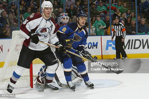 Paul Kariya of the St. Louis Blues battles Paul Stastny of the Colorado Avalanche for position in front of goaltender Peter Budaj on March 16, 2010...