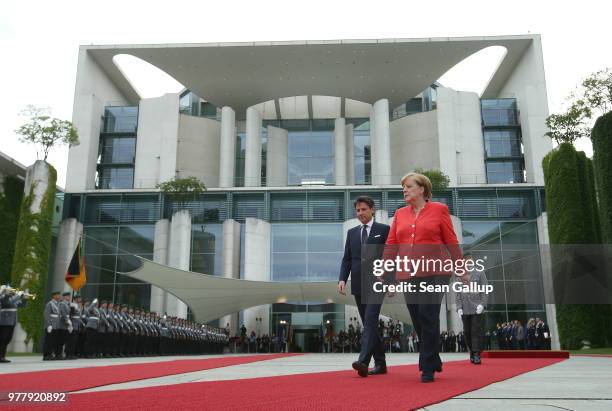 German Chancellor Angela Merkel and Italian Prime Minister Guiseppe Conte review a guard of honor upon Conte's arrival at the Chancellery on June 18,...