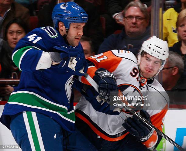 Andrew Alberts of the Vancouver Canucks battles for position against John Tavares of the New York Islanders during their game at General Motors Place...