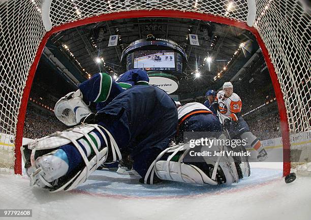 Sean Bergenheim of the New York Islanders looks on as the puck slides past Roberto Luongo of the Vancouver Canucks during their game at General...