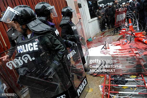 Riot policemen stand beside flattened barricades after supporters of deposed Thai premier Thaksin Shinawatra spilled blood they had collected as part...