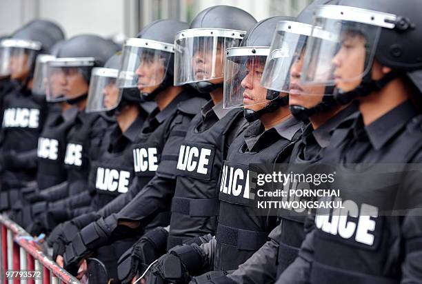 Thai riot policemen stand guard as supporters of deposed Thai premier Thaksin Shinawatra protest at the US embassy in Bangkok on March 17, 2010....