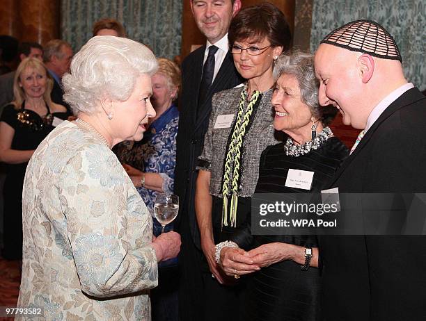 Queen Elizabeth II meets Joan Burstein, from Browns, and milliner Stephen Jones at a reception for the British Clothing Industry, including an...