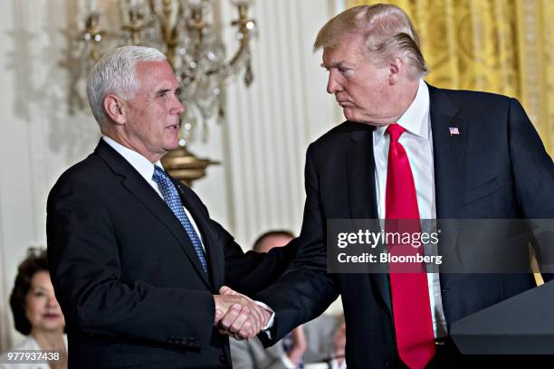 President Donald Trump, right, shakes hands with U.S. Vice President Mike Pence during a National Space Council meeting in the East Room of the White...