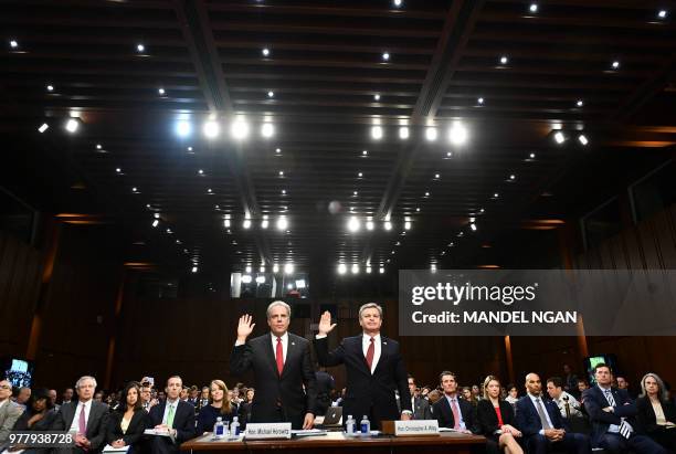 Justice Department Inspector General Michael Horowitz and FBI Director Christopher Wray take an oath before testifying to the Senate Judiciary...