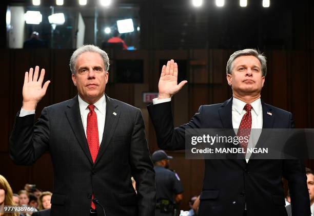 Justice Department Inspector General Michael Horowitz and FBI Director Christopher Wray take an oath before testifying to the Senate Judiciary...