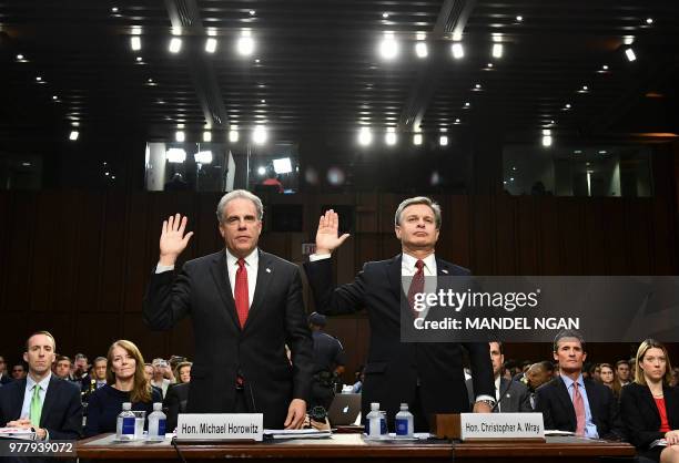 Justice Department Inspector General Michael Horowitz and FBI Director Christopher Wray take an oath before testifying to the Senate Judiciary...