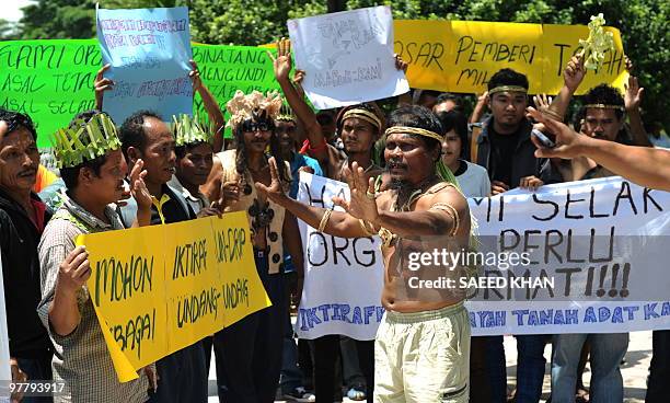 Members of Malaysia's indigenous tribes shout slogans while holding placards in front of the Prime Minister's office in Putrajaya during a protest on...