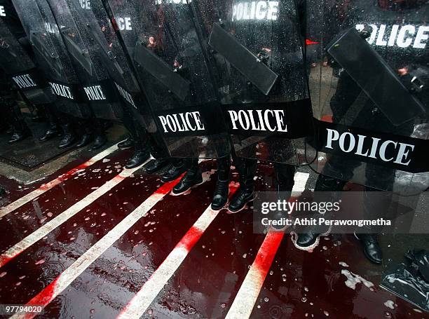 Riot police guard the residence of Thai Prime Minister Abhist Vejjajiva as supporters of deposed Thai Prime Minister Thaksin Shinawatra throw human...