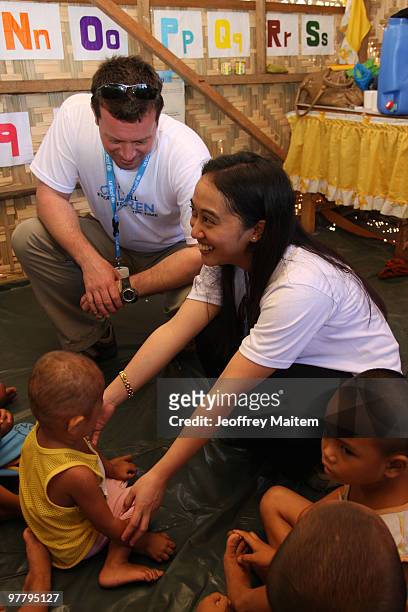Patrick Halton of England, UNICEF Philippines Child Protection specialist, and a Filipino co-worker are seen with children affected by the fighting...