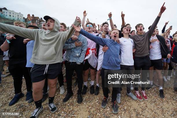 Football fans belt out the national anthem as they get ready to watch the match inside the Lunar Beach Cinema on Brighton beach as England play...